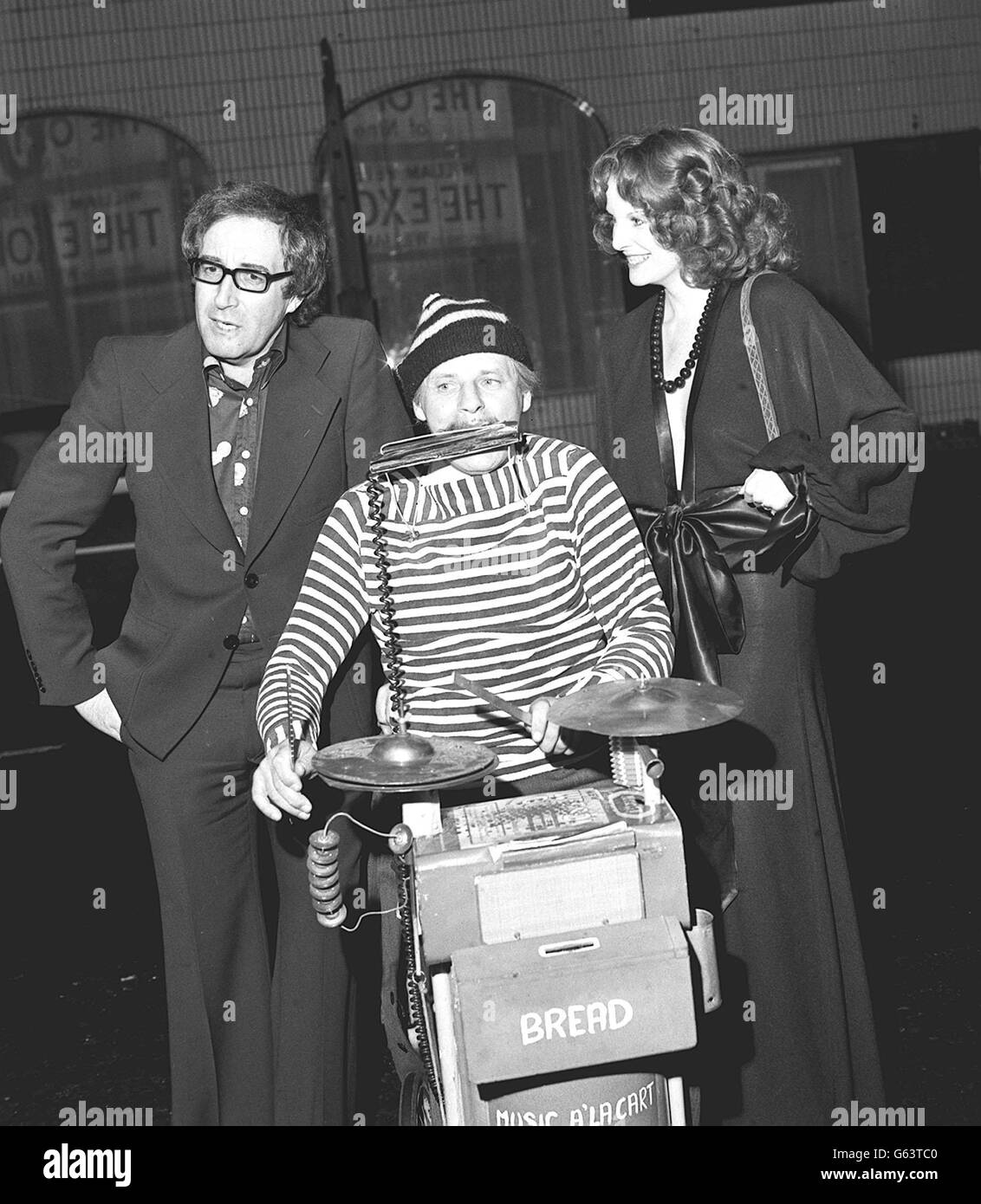 Peter Sellers, who plays a busker in "The Optimists of Nine Elms" pauses for a word with busker Johnny Magoo as he arrives with friend Shun Huston, to attend the charity premiere of the the film. Stock Photo