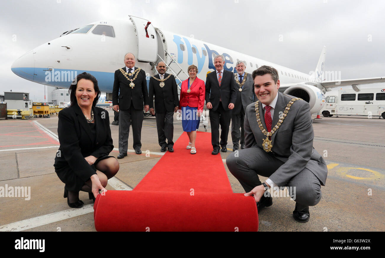 Flybe marks 30 years of operations in Northern Ireland by flying in dignitaries from five key destinations for a special visit, arriving at George Best Belfast city airport. Rolling out the red carpet are (left to right) Andrea Hayes, regional manager Flybe, the Lord Mayor of Birmingham, Councillor John Lines, the Lord Mayor Elect of Manchester, Councillor Naeem Ul Hassan, the Lord Mayor of Exeter, Councillor Rachel Lyons, the Provost of Inverness, Councillor Alexander Graham, the Mayor of Southampton Councillor Ivan White and Belfast Lord Mayor, Alderman Gavin Robinson. Stock Photo