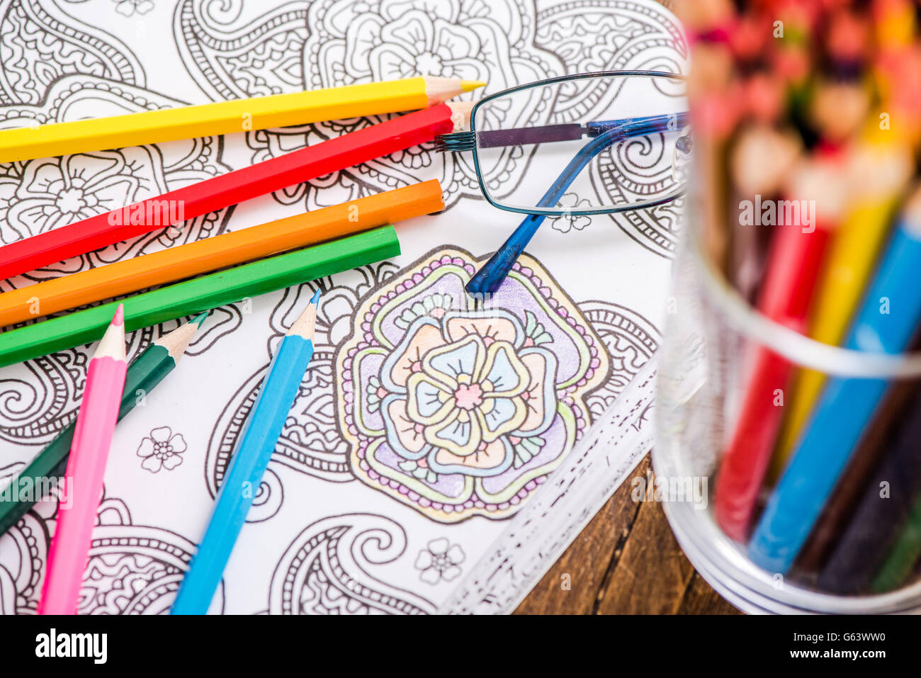 relaxing with adult coloring book, on wooden table Stock Photo