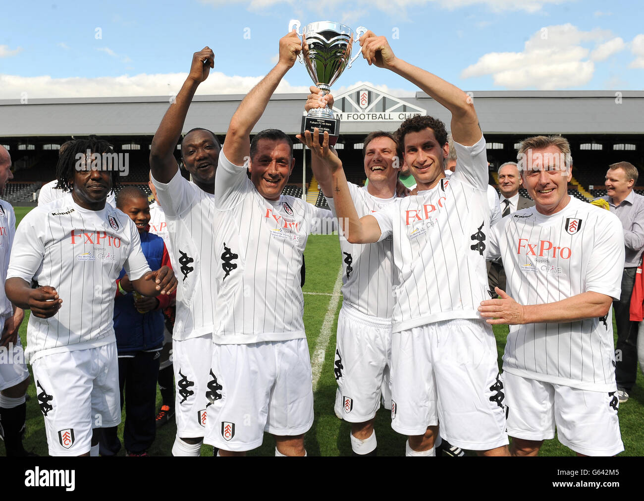 Soccer - Charity All Star Match - Fulham v Sealand - Craven Cottage. Fulham's Captain, All Stars Karim Fayed (2nd right) lifts the Shooting Stars Chase Cup after victory over the Sealand All Stars. Stock Photo