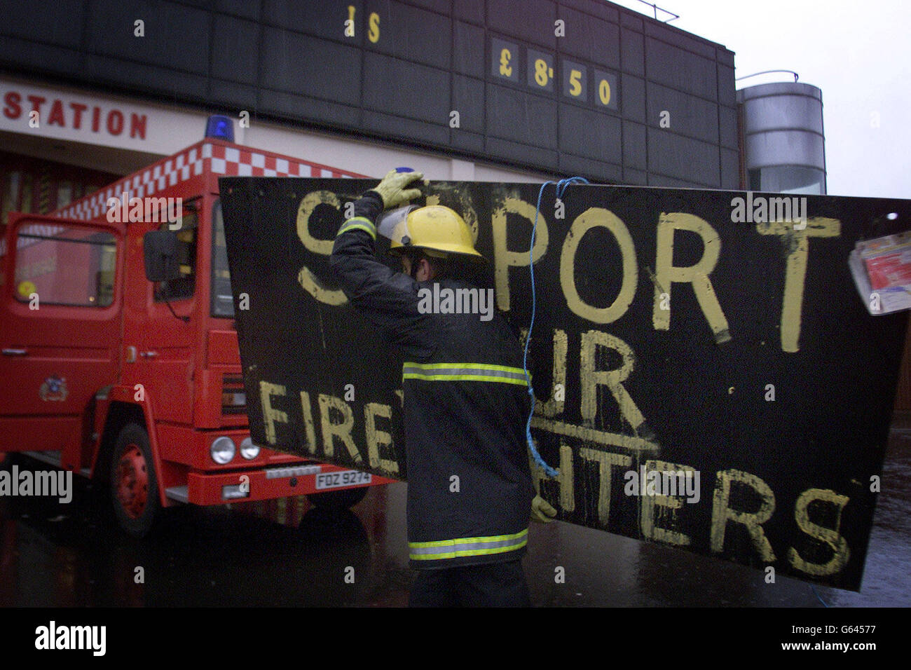 A Firefighter at Central Station in Belfast removes the strike banner from the front of the station, as the eight day nationwide strike comes to an end. Stock Photo