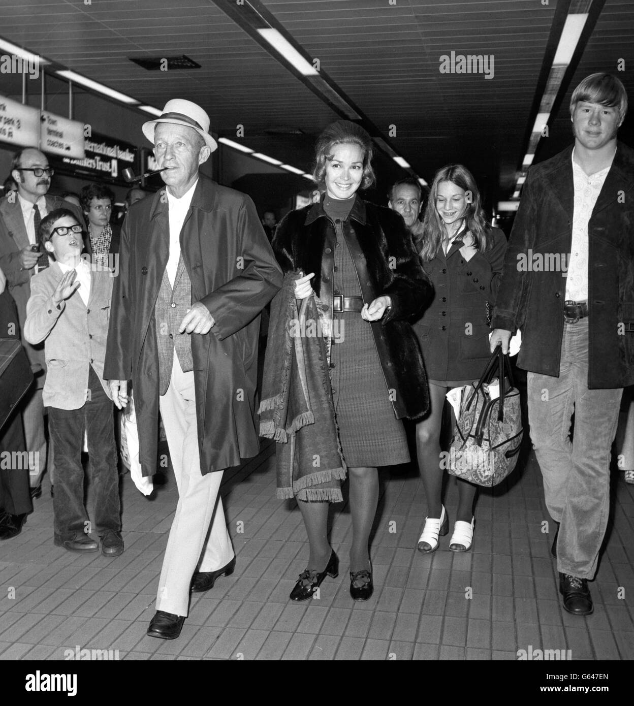 Hollywood crooner Bing Crosby, who is known to his friends as Old Groaner, arrives at Heathrow Airport from New York. With him are his wife, Katherine, daughter Mary (background right) and nephew Bill Myers (right). Stock Photo