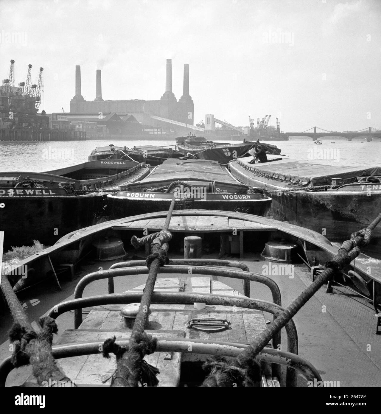 A view of cargo barges on the Thames, with Battersea Power Station in the background. Stock Photo