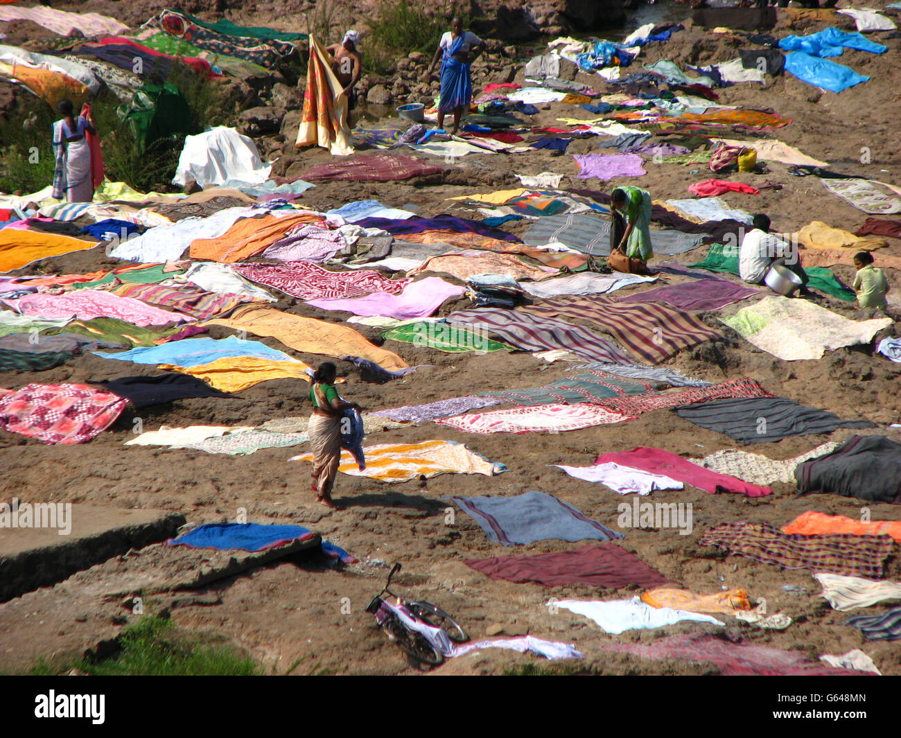 Indian villagers drying their clothes on rocks after washing them in