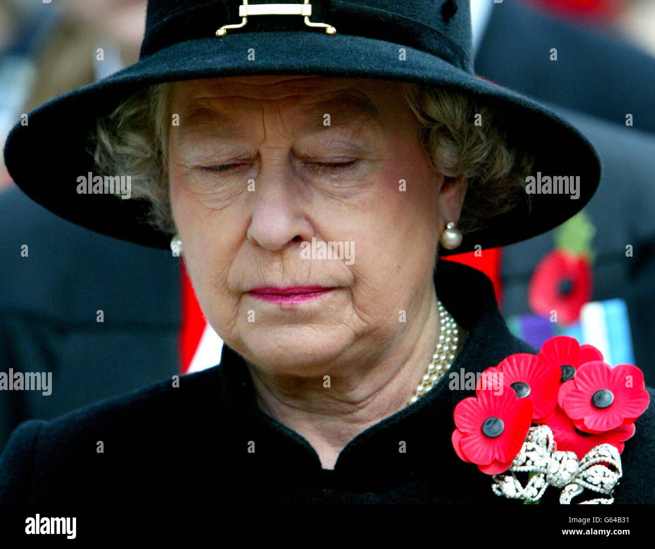 Queen Elizabeth II sheds a tear during the Field of Remembrance Service at Westminster Abbey, London. The Queen opened the ceremony - the annual open air service in St Margaret's churchyard, held in memory of Britain's war heroes. * ... - by laying down a small wooden cross bearing a scarlet poppy in the field. Stock Photo
