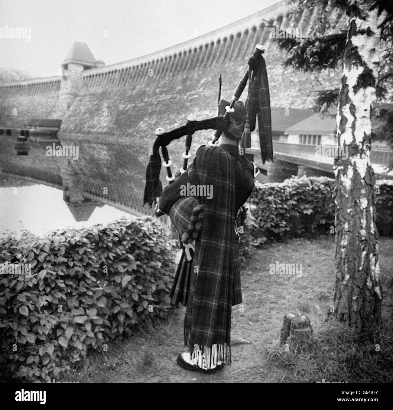 Gordon Highlander, Lance Corporal Tam Inglis, of Kincardine, playing a lament at the Mohne Dam in West Germany for those who died in the 'Dambusters' raid on May 17, 1943. Stock Photo