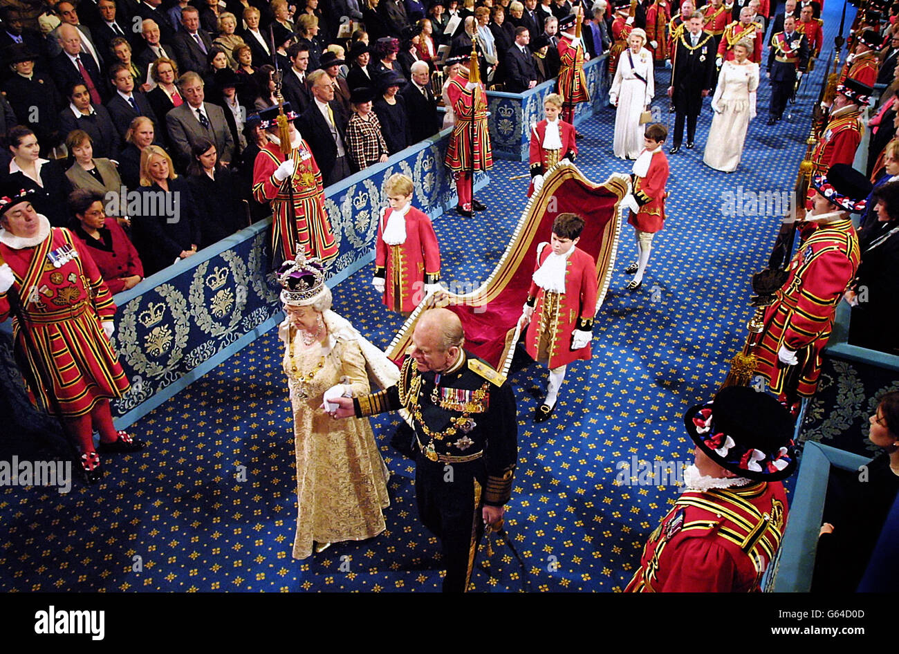 Britain's Queen Elizabeth II, wearing the Imperial Crown, escorted by her husband Prince Philip, The Duke of Edinburgh, walk in procession through The Royal Gallery on her way to give her speech during the ceremonial state opening of Parliament. Stock Photo