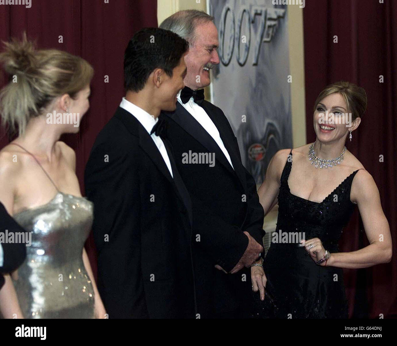 Madonna shares a joke with John Cleese as they wait in line to meet Queen Elizabeth II and The Duke of Edinburgh at the premiere of 'Die Another Day', at the Royal Albert Hall. Stock Photo