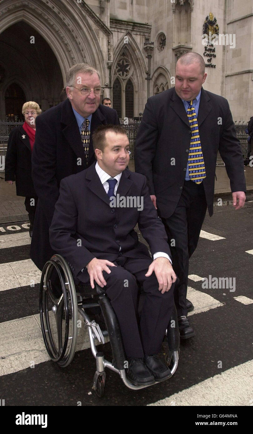 29-year-old Richard Vowles (in wheelchair), his father Bernard (left) and his brother Matthew (right) leave the High Court in London, after Richard won a damages claim against the Welsh Rugby Union. *..Richard was left paralysed after an accident during an amateur match for which the WRU have accepted vicarious liability. He had brought a damages action against match referee David Evans, who Mr Justice Morland said had been in breach of his duty to take reasonable care for the safety of the front row forwards in failing to order non-contested scrums. The amount of damages will be assessed Stock Photo