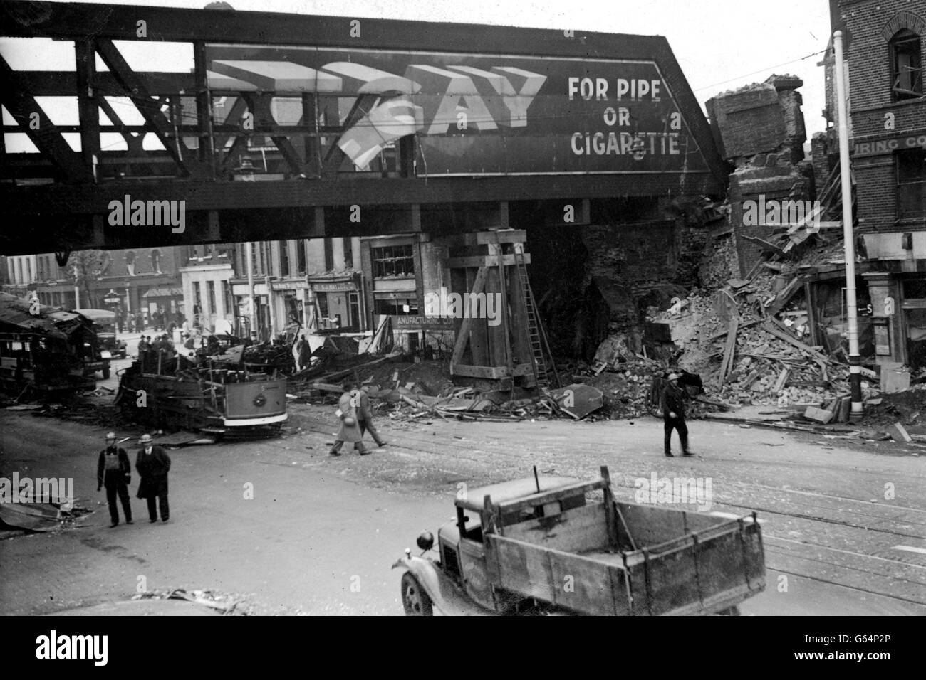 1941: The scene after a bomb had been dropped through a railway bridge and badly damaged tramcars during a Luftwaffe daylight raid on London. Stock Photo