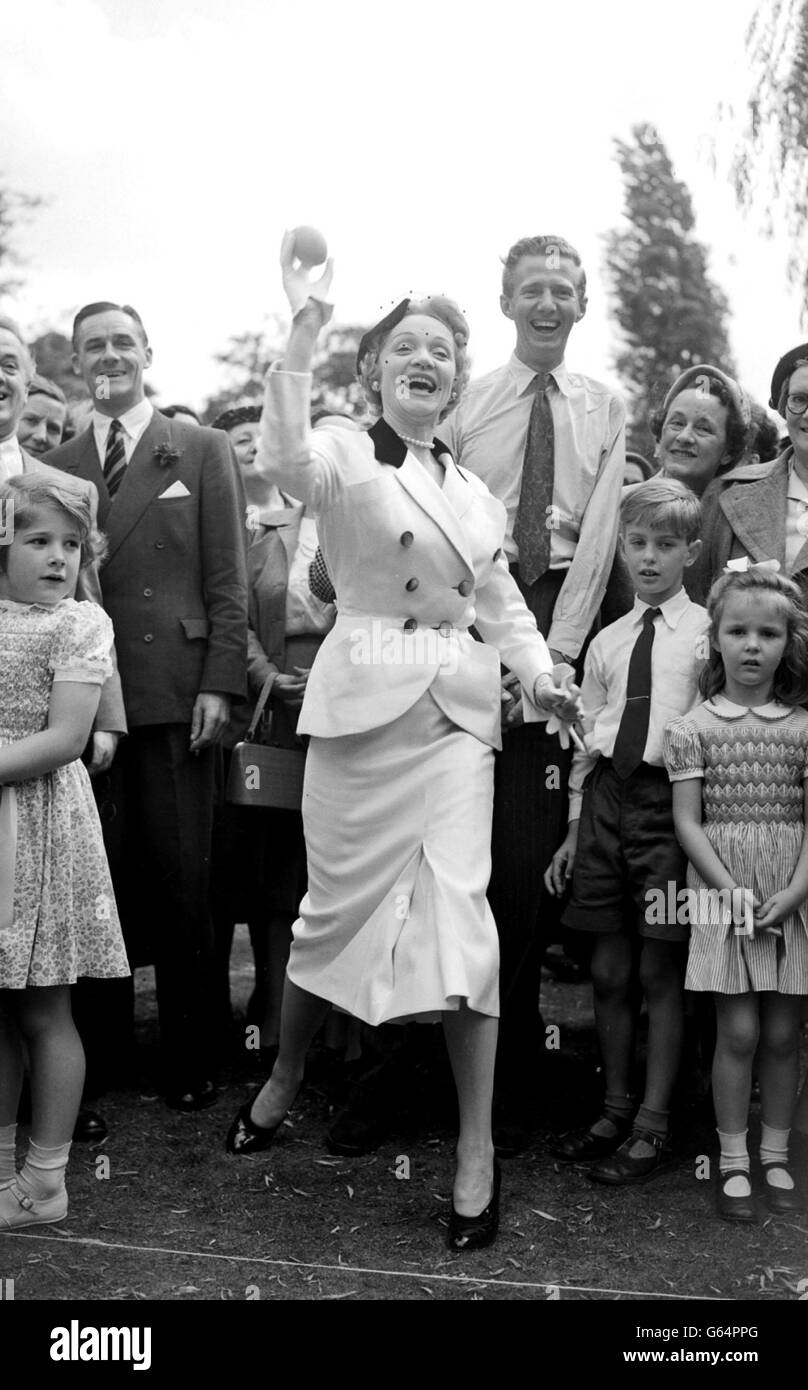Marlene Dietrich tries her skill at the coconut-shy after opening a garden party in aid of the Sunshine Homes for Blind Babies at the Holme, Inner Circle, Regent's Park, London. Stock Photo