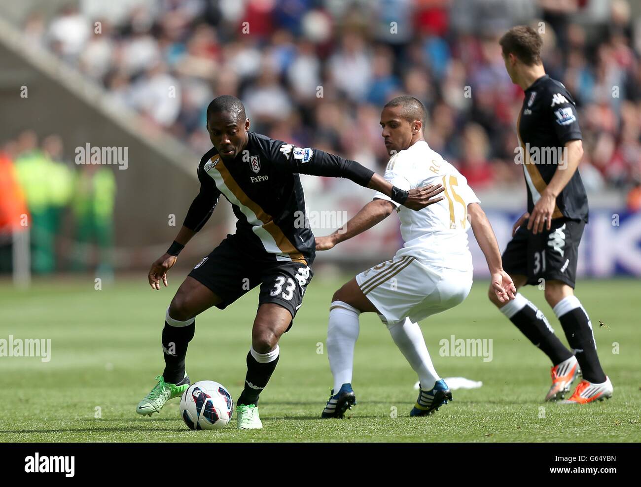 Soccer - Barclays Premier League - Swansea City v Fulham - Liberty Stadium. Fulham's Eyong Enoh (left) and Swansea City's Wayne Routledge (right) battle for the ball Stock Photo