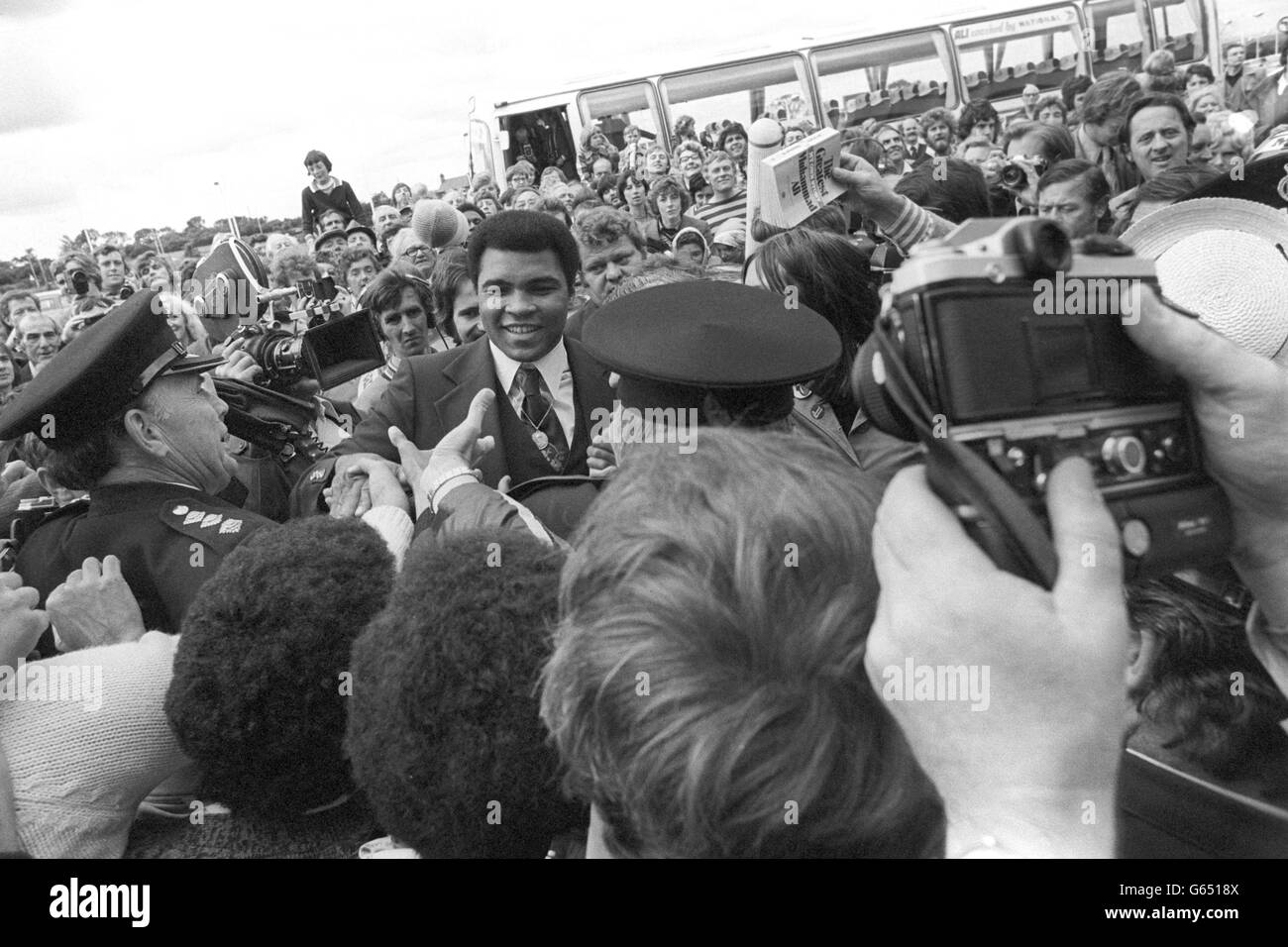 Anxious policemen surround World Heavyweight Boxing Champion Muhammed Ali as he is greeted by a huge crowd at Newcastle Airport. Ali, who flew in with his wife Veronica and their 11-month-old daughter, Hana, from Chicago this morning, had kept the crowd waiting for over five hours because he had missed his connection from Heathrow Airport. The champion boxer was travelling to the North East to visit boys' boxing clubs across Tyneside and help raise money for them. Stock Photo