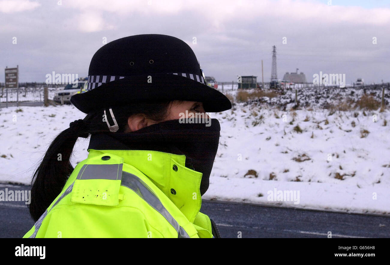 A police woman protects her face against the cold while on duty for the Secretary of State for Defence, Geoff Hoon visit to RAF Fylingdales Monday 6 January 2003, on the North Yorkshire Moors. Stock Photo