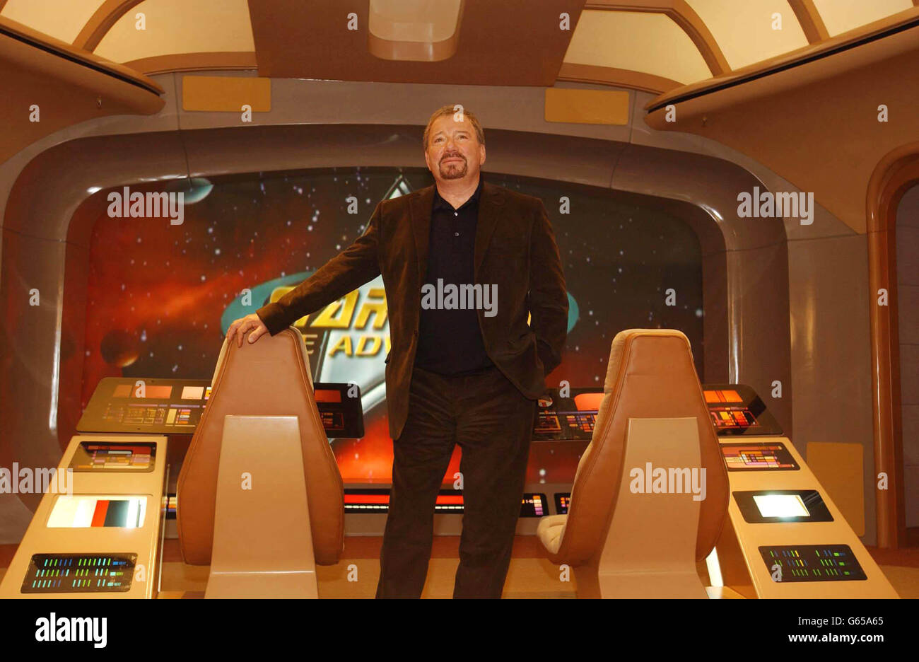 Former commander of the Starship Enterprise Captain Kirk (US actor William Shatner) sits on the bridge of a mock up of the Enterprise at Star Trek: The Adventure - an exhibition celebrating 35 years of the TV show and feature films - at Hyde Park. Stock Photo