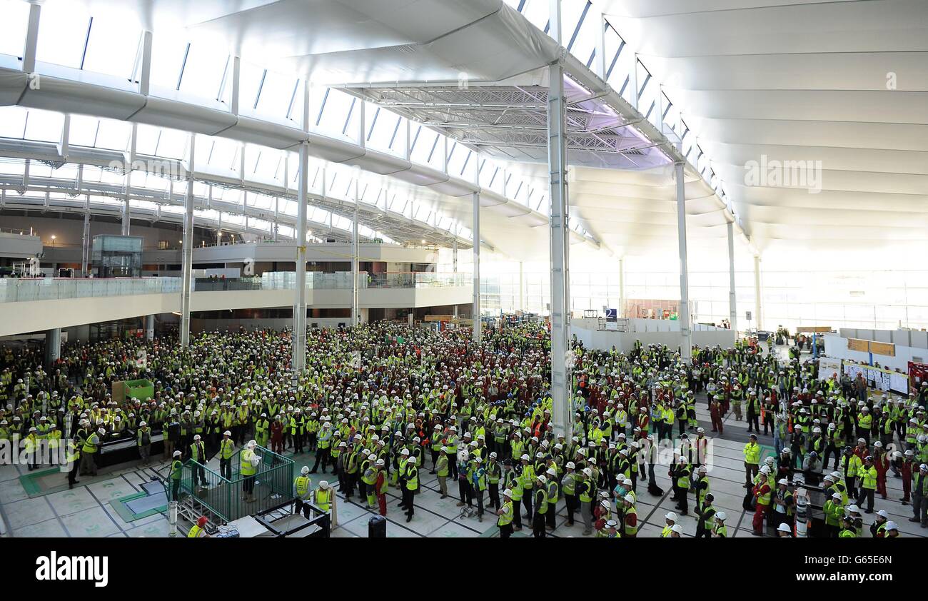Workers gather together in the departures hall of Heathrow's Terminal 2 for a talk by Developing Director John Holland-Kaye during a media day marking One Year to Go until Terminal 2 re-opens. Stock Photo