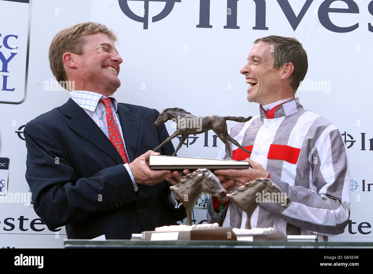 Horse Racing - The Investec Ladies Day - Epsom Downs Racecourse. Jockey Richard Hughes (right) and trainer Ralph Beckett (left) celebrate with the trophy after winning The Investec Oaks with Talent Stock Photo