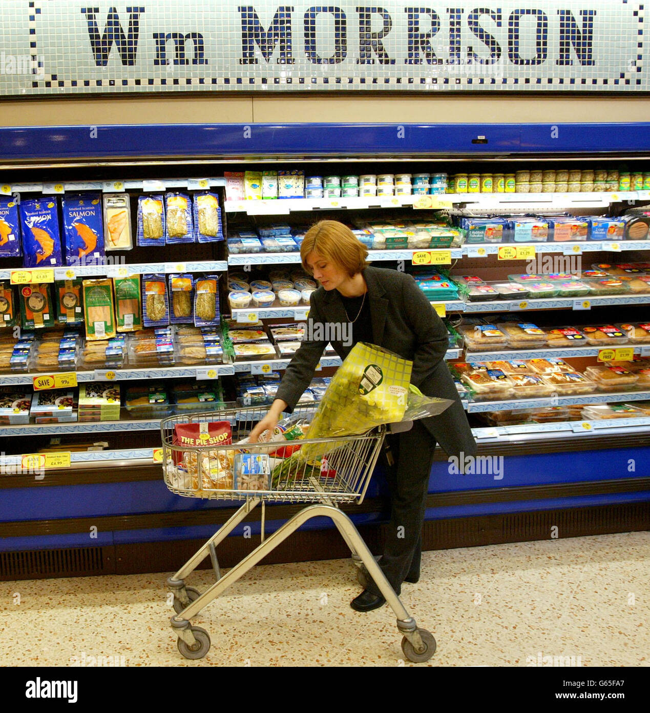A shopper in Morrison's Supermarket in Winsford, Cheshire. Supermarket giant Sainsbury gatecrashed rival Morrisons agreed takeover of Safeway with details of a bumper 3.2 billion bid. *..The group said it was considering an offer of at least 300p per share in a move that is certain to spark a bidding war in the sector. Analysts believe Asda, backed by the might of its US owner Wal-Mart, will now declare its hand and trump both bids currently on the table. The mounting speculation was enough to push Safeway shares up by 5% in the City - its market value has soared 37% in under a week. Stock Photo