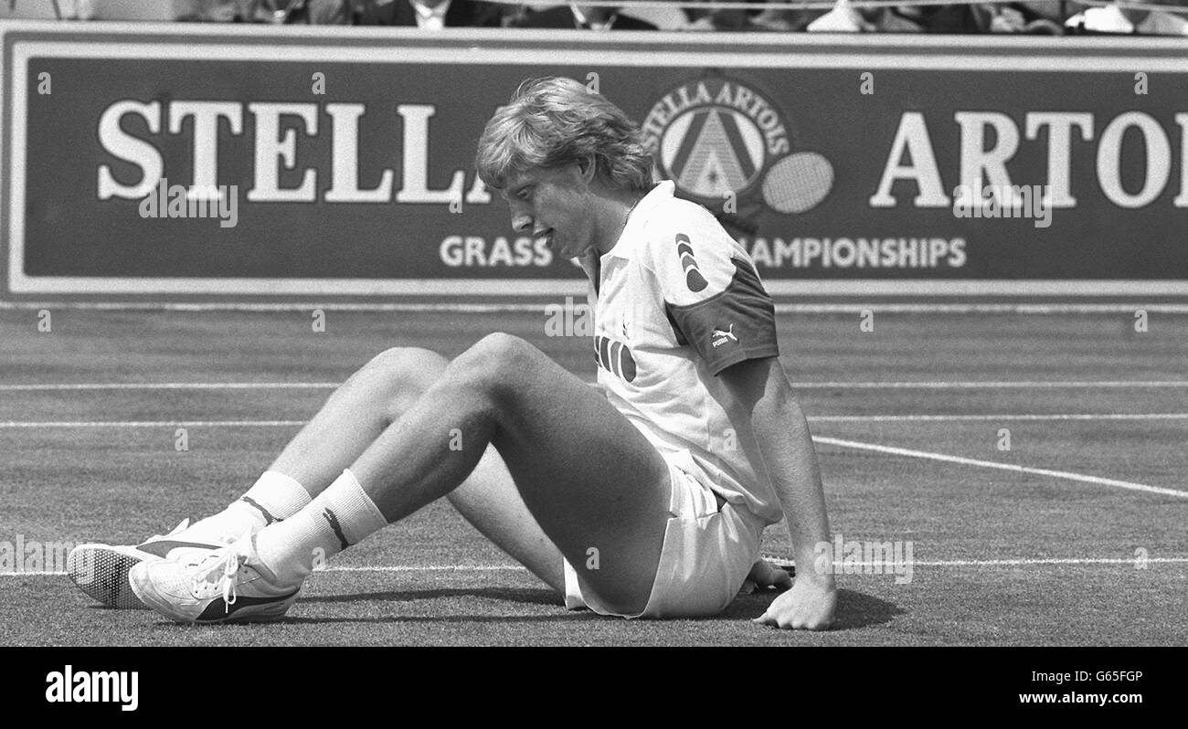 West Germany's Boris Becker sits on the floor after falling during his match against America's Jimmy Connors in their final of the Stella Artois grass court championships at Queen's Club, London. Stock Photo