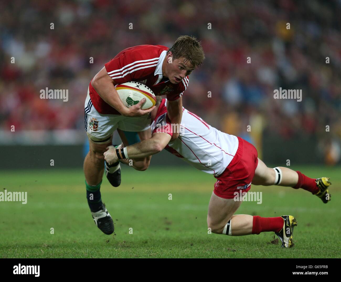 British and Irish Lions' Jonathan Davies is tackled by Queensland Reds' Ben Lucas Stock Photo