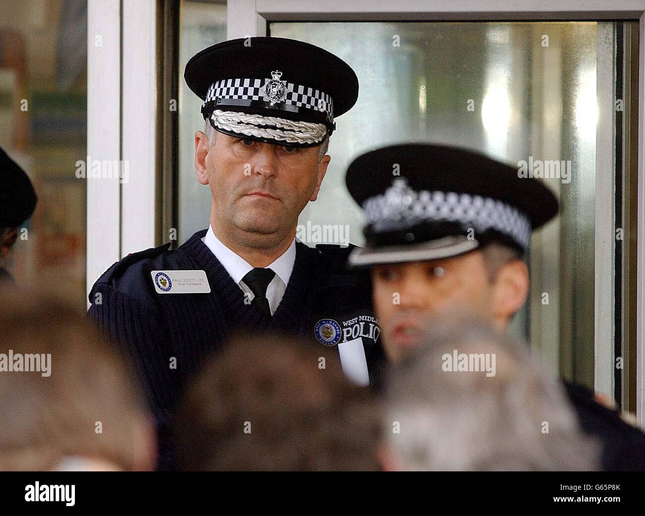 Chief Constable of the West Midlands Police Paul Scott-Lee watches Chief Superintendent David Shaw at Queens Road Police Station, as he addresses a press conference about the investigation into the deaths of two women behind a hairdresser's shop. *... on Birchfield Rd in Aston, Birmingham. Another two are in hospital being treated for gunshot wounds. Stock Photo