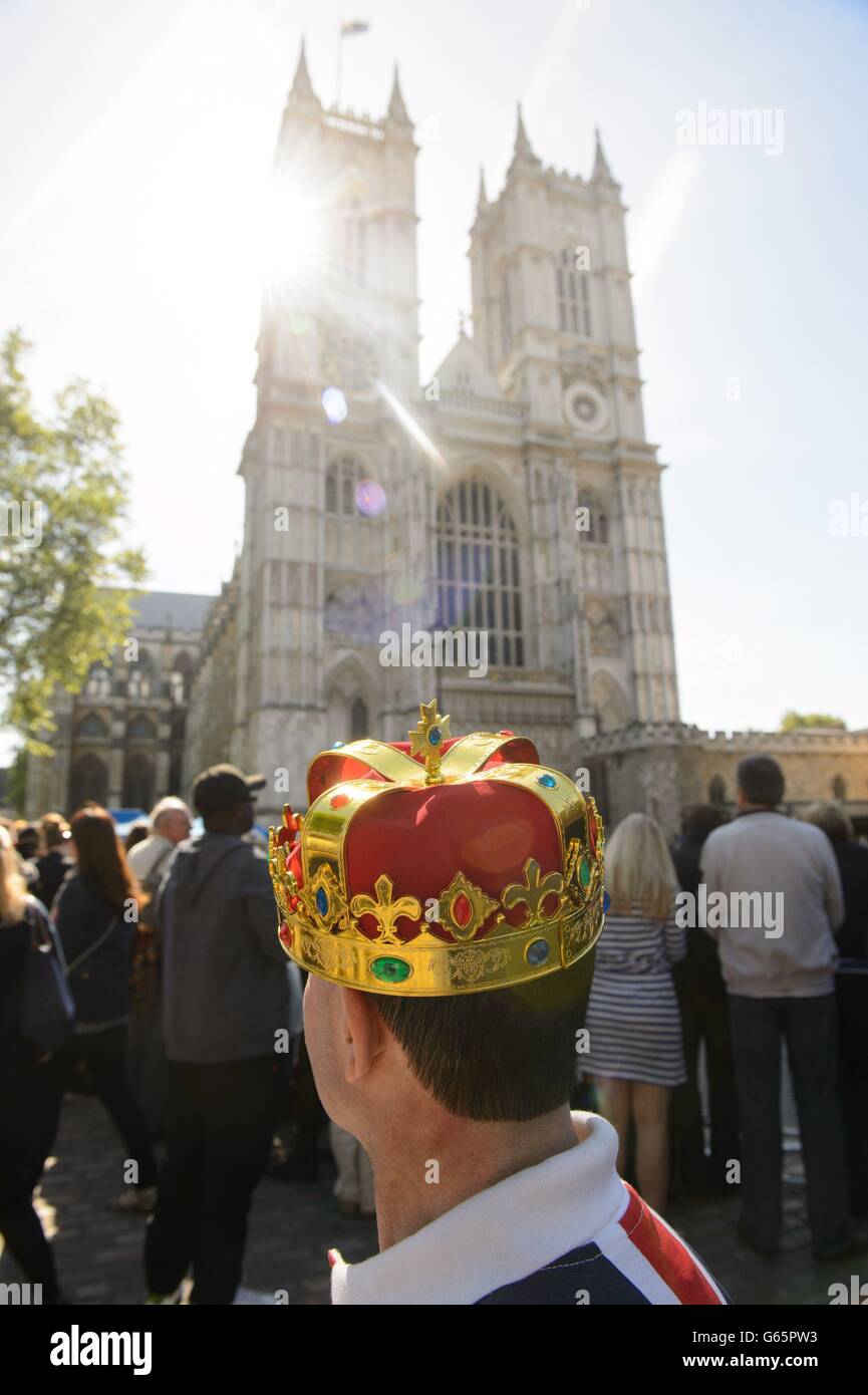 A man wearing a crown waits outside Westminster Abbey, in central London, ahead of a service of celebration to mark the 60th anniversary of Queen Elizabeth II's coronation. Stock Photo
