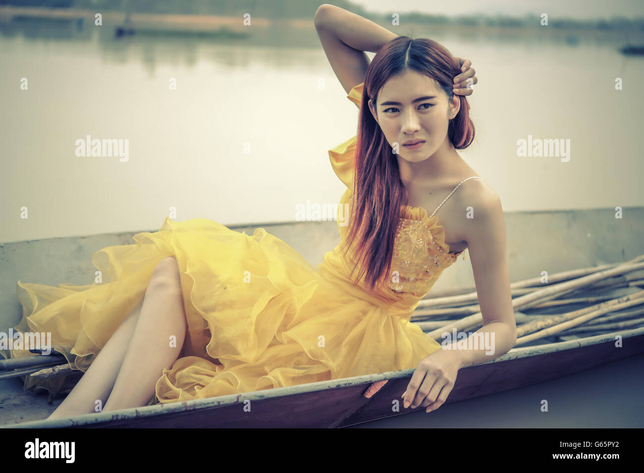 Portrait of Asia Beautiful woman in yellow dress sitting on boat Stock ...