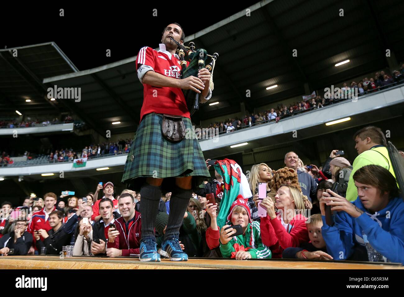 Rugby Union - 2013 British and Irish Lions Tour - Western Force v British and Irish Lions - Patersons Stadium. A man playing the bagpipes to the British and Irish Lions' squad as they leave the pitch after the final whistle Stock Photo