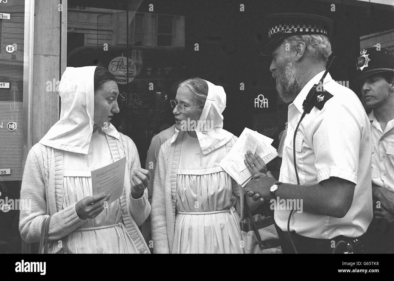 Sister Andrea (left) and Sister Thekla, nuns from the Evangelical Sisterhood of Mary in Hertfordshire, receive a request from the police to move to the other side of the road as they distribute leaflets outside the Plaza Cinema in Piccadilly, London, where the controversial film 'The Last Temptation of Christ' opened and attracted some demonstrators. Stock Photo