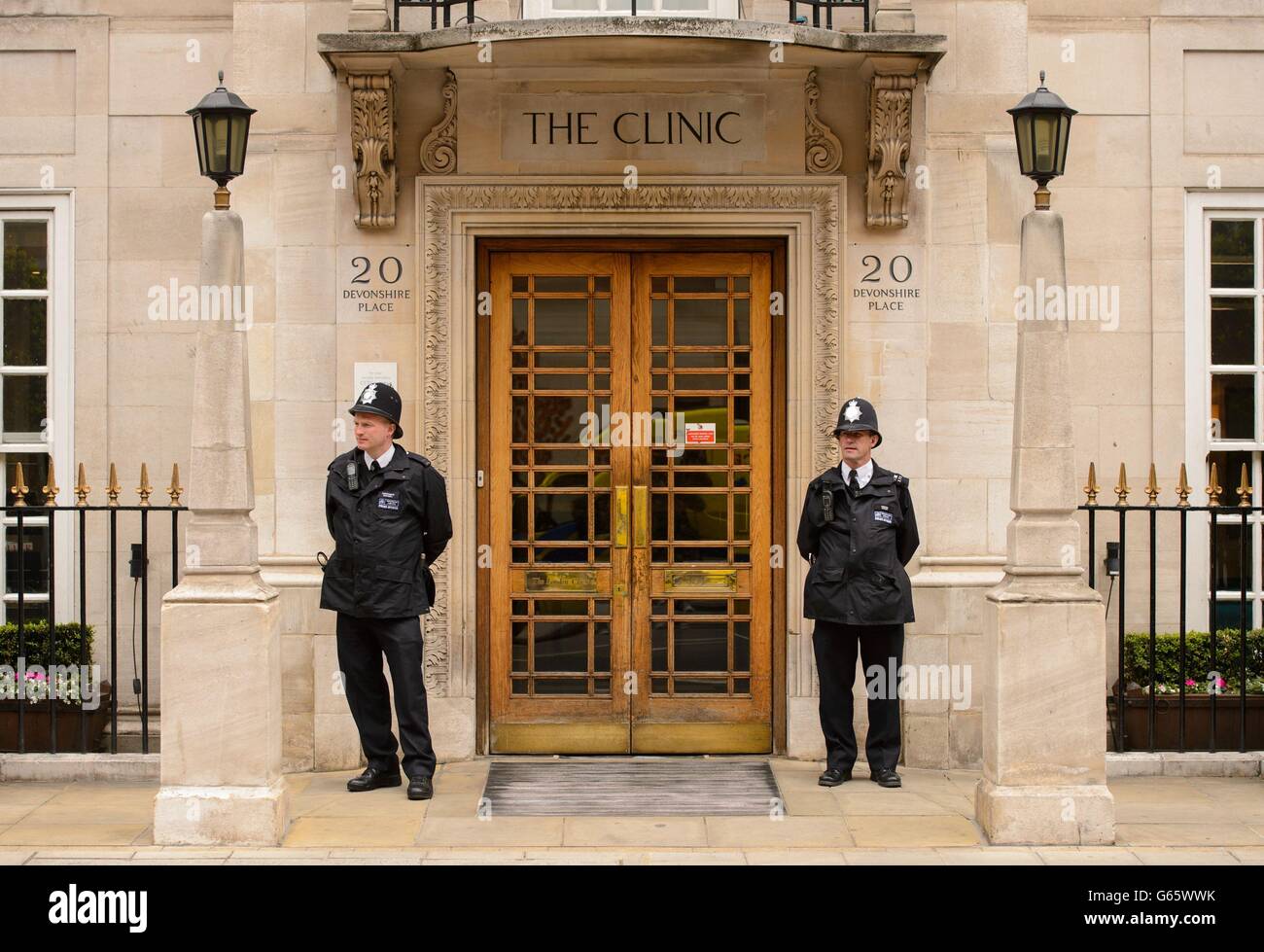 Police officers stand guard outside the London Clinic, in central London, where the Duke of Edinburgh is being treated after being admitted for an exploratory operation on his abdomen. Stock Photo