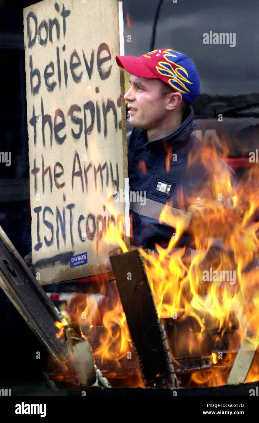 A firefighter from the Marionville Fire Station in Leith, Edinburgh, holds up a banner,as part of a nationwide 24 hour strike over pay. Stock Photo