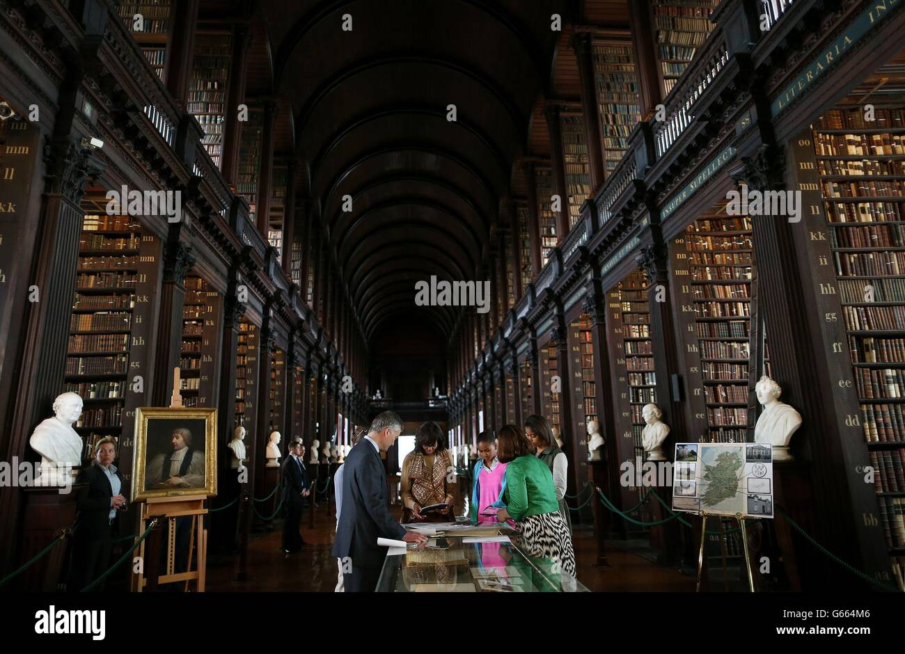 US First Lady Michelle Obama with her daughters Sasha (centre) and Milia Ann view the Obama Family Collection, with Fiona Fitzsimons (right), Director of Eneclann and Dr. Patrick Prendergast (left) during their visit to the Long Hall Library in Trinty, Dublin, where they also viewed the World Famous Book of Kells. Stock Photo