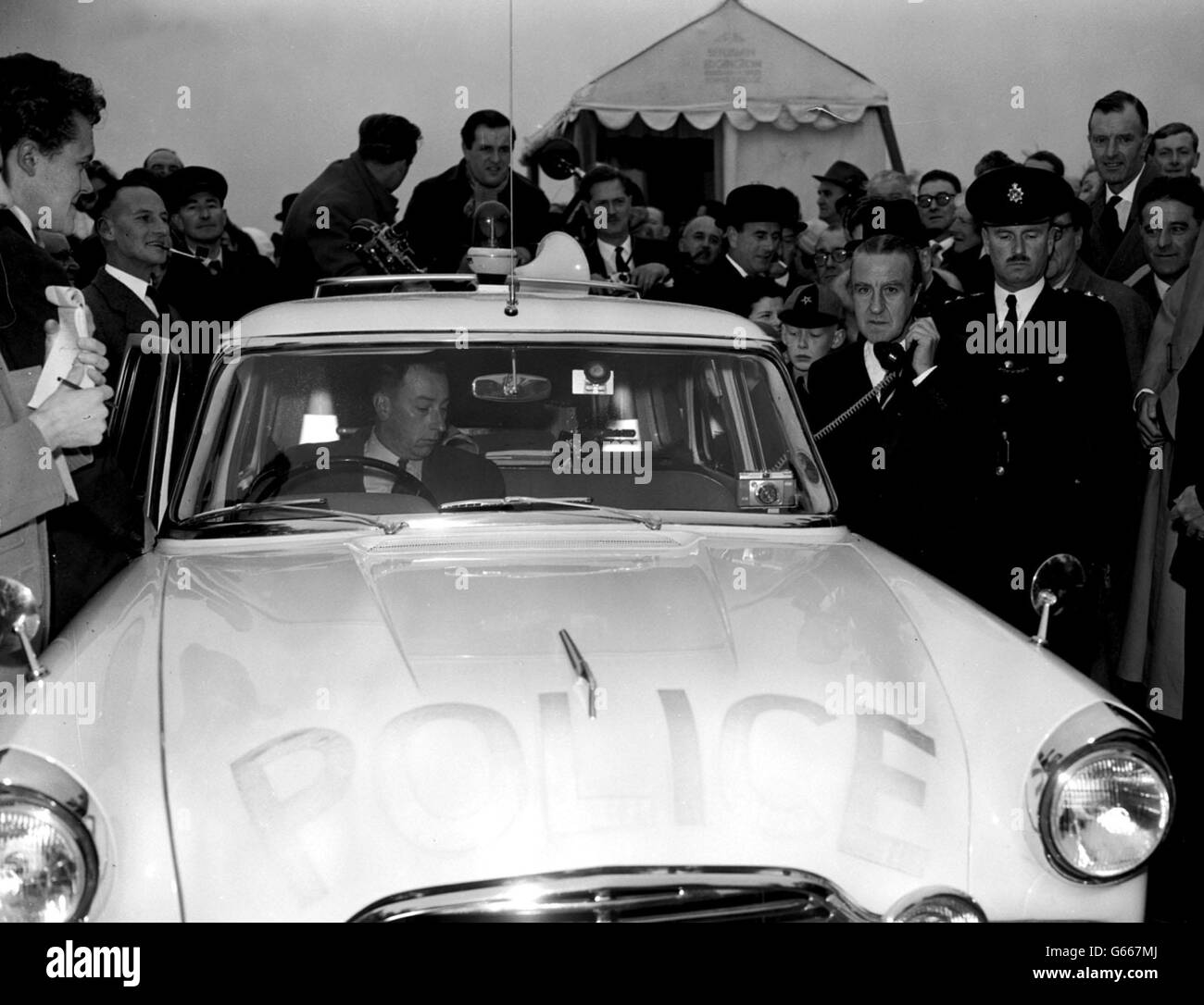 Using the microphone of a police patrol car, Mr Ernest Marples, the Minister of Transport, gives a signal to the County police along the route to open Britain's first long-distance motorway -- the 72-miles long London-Birmingham Motorway (M1) -- to traffic. The short informal opening ceremony took place at Slip End near the Luton Spur which joins the motorway to the A6 road just south of Luton, Bedfordshire. Slip End is the point where construction of the M1 was inaugurated 19 months ago. Stock Photo