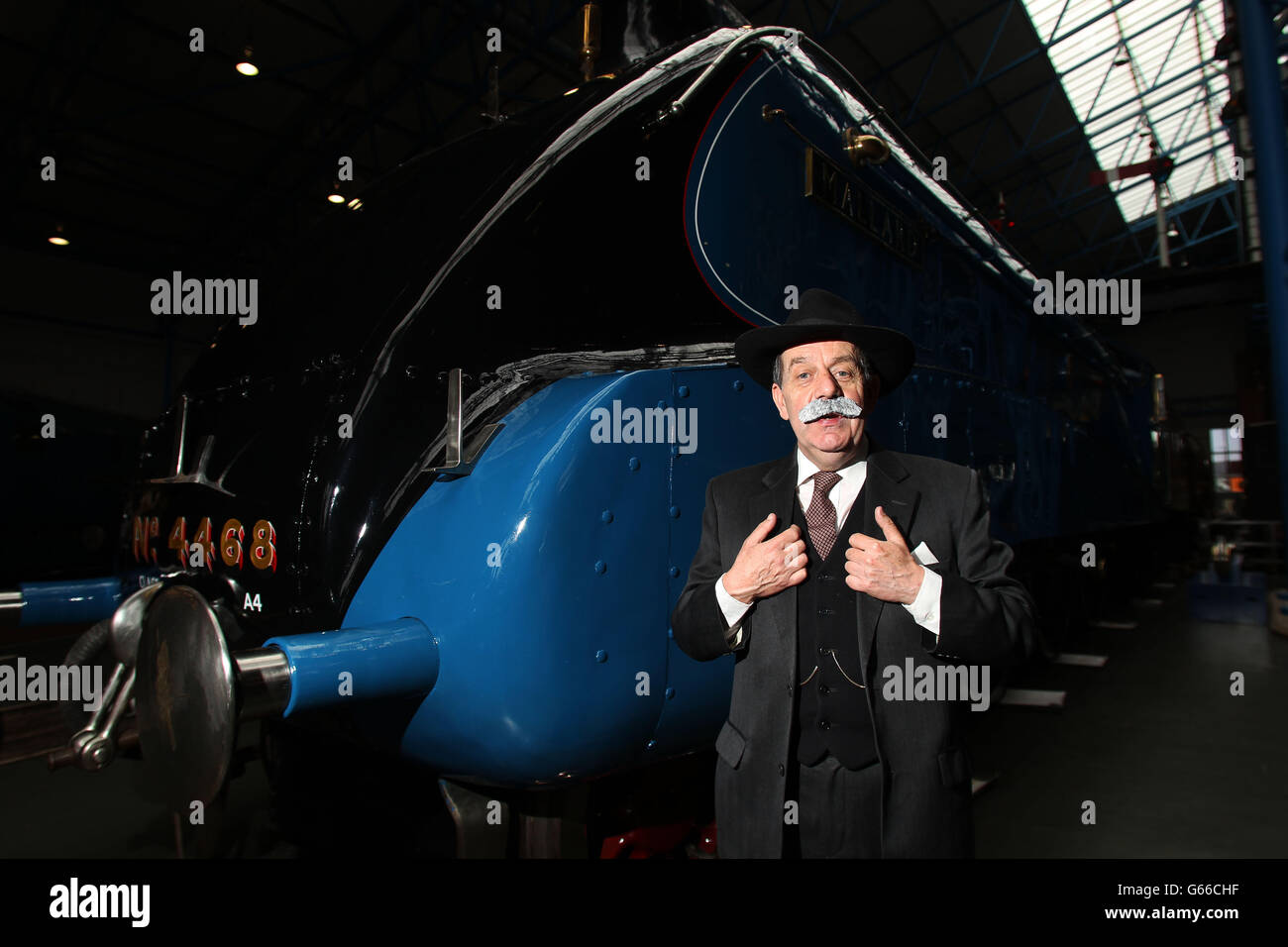 Chris Cade from Platform 4 Theatre dressed as Sir Nigel Gresley next to The Mallard, at The National Railway Museum, York as its marks the birthday of Sir Nigel Gresley in the run up to the 75th anniversary of The Mallard breaking the world steam record. Stock Photo