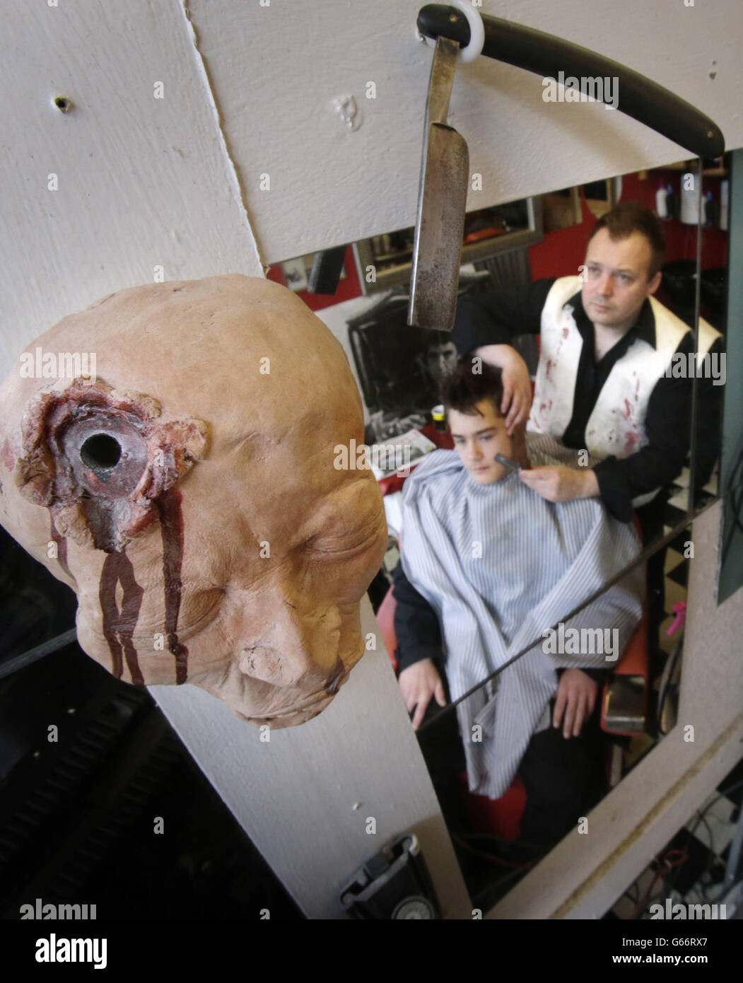 Previously unissued photo dated 25/06/13 of Will Robertson shaving his son Benn Robertson at his Sweeney Todd Demon Barber themed barber shop in Pitlochry, Scotland. Stock Photo