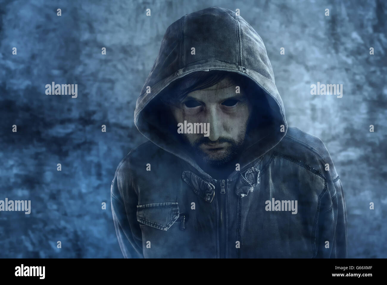 Spooky ghost appearance of dead male person with black eyes and hooded jacket Stock Photo