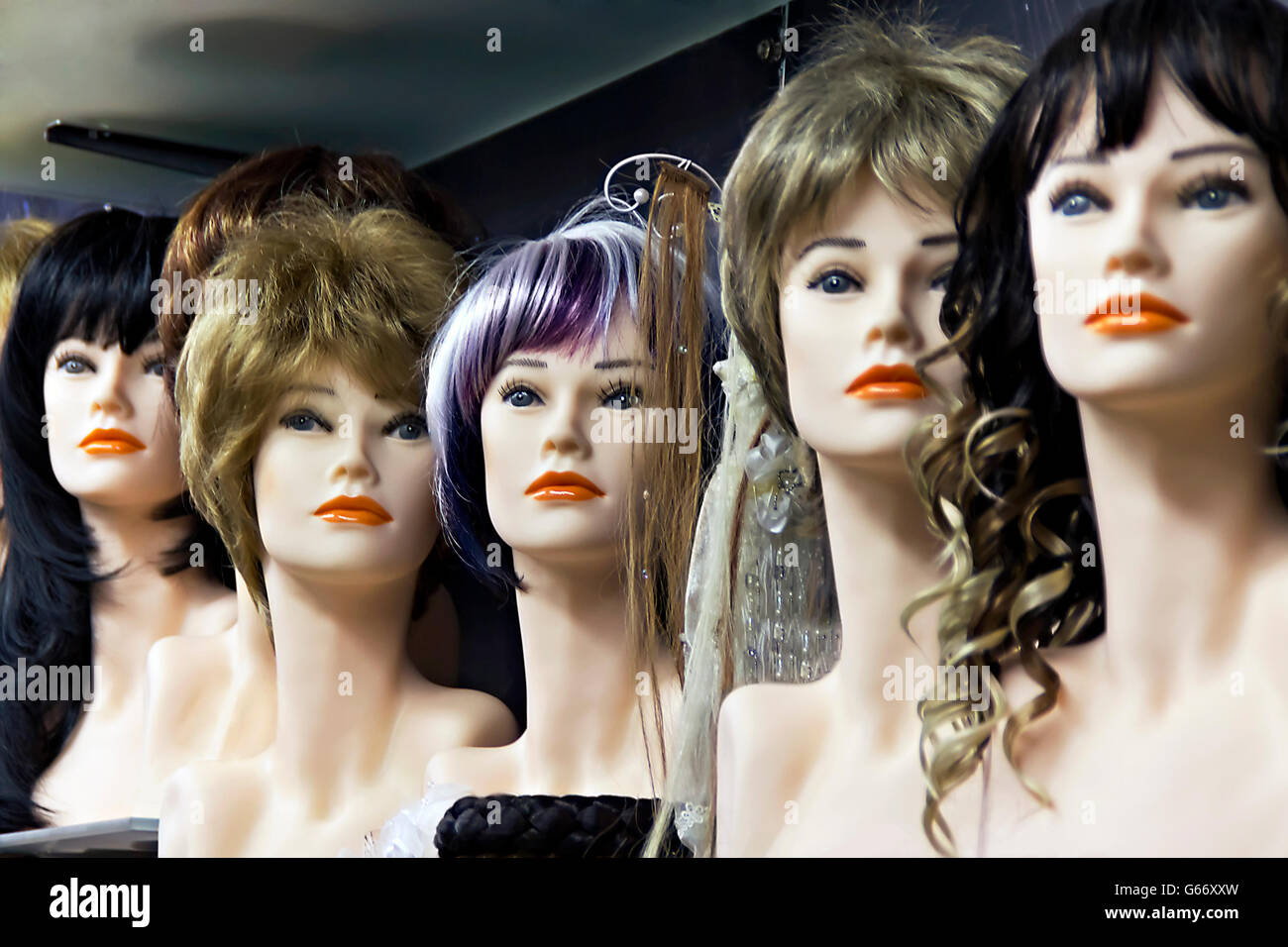 Several female mannequins with wigs on the shelf Stock Photo Alamy