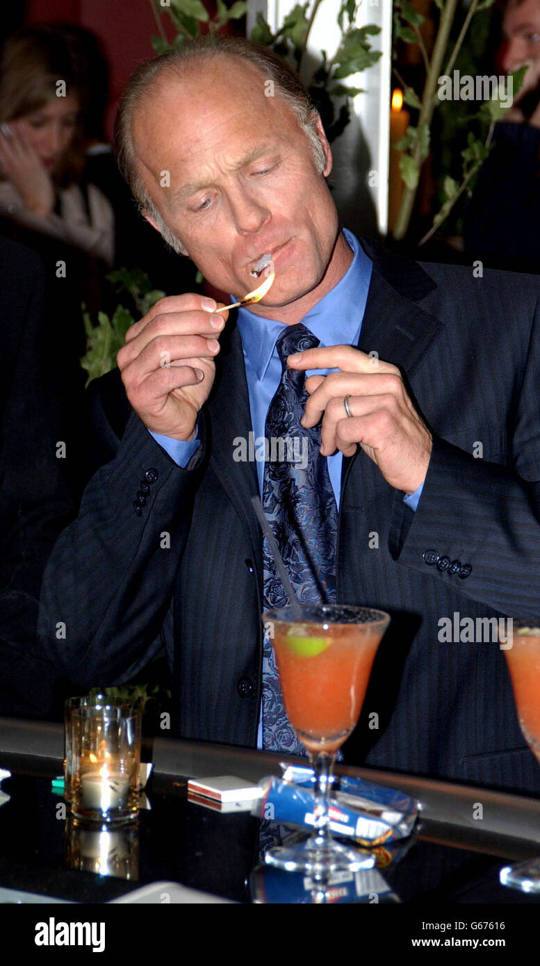 Actor Ed Harris lights a cigarette during a press reception at the