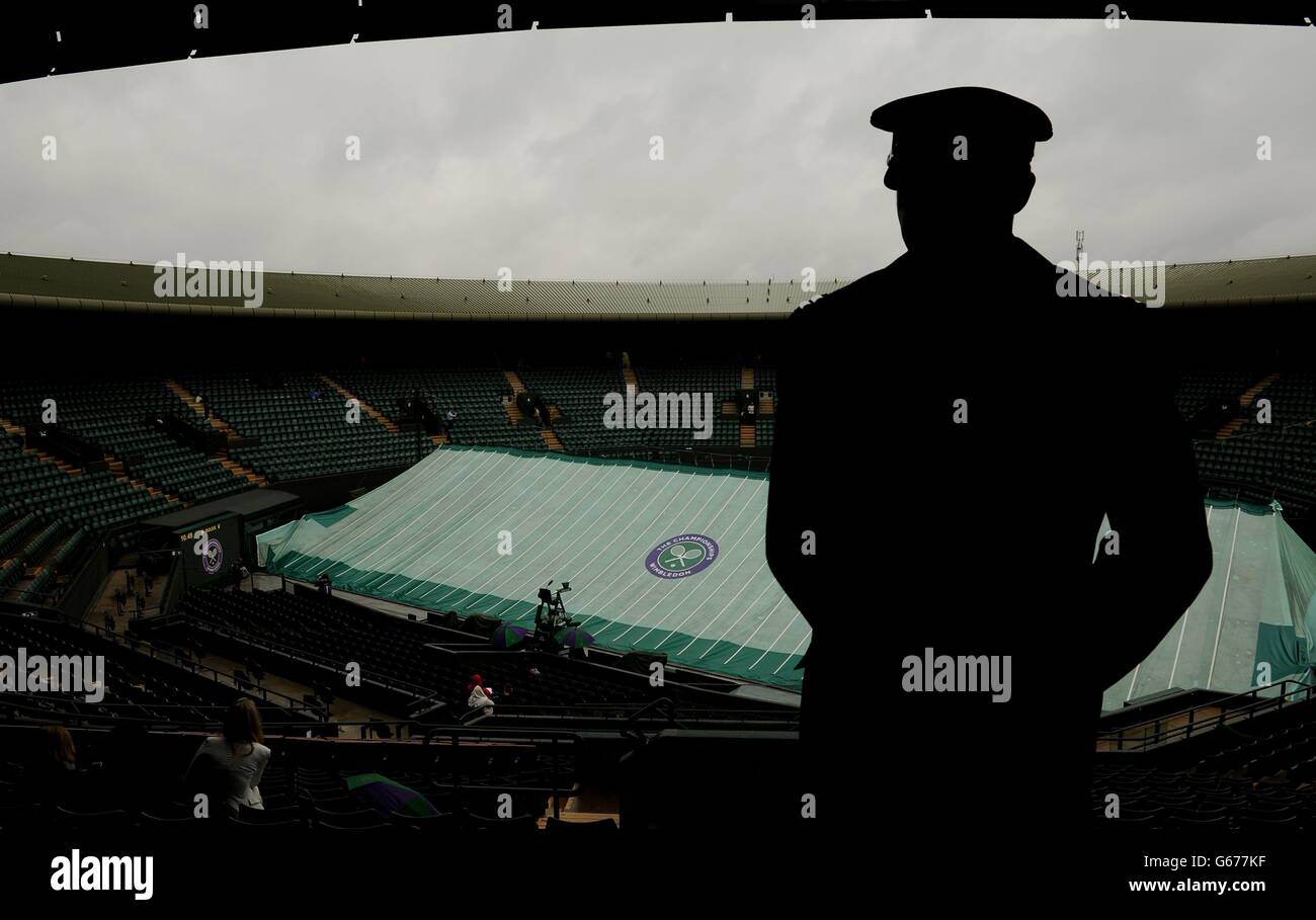 A member of the London Fire Bridgade keeps watch over Court One as rain falls during day five of the Wimbledon Championships at The All England Lawn Tennis and Croquet Club, Wimbledon. Stock Photo