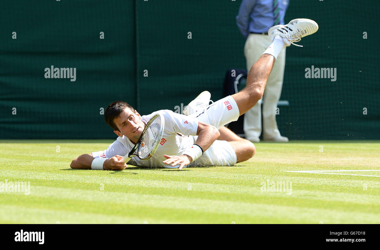 Serbia's Novak Djokovic slides on the floor after reaching for a shot in his match against Argentina's Juan Martin Del Potro during day eleven of the Wimbledon Championships at The All England Lawn Tennis and Croquet Club, Wimbledon. Stock Photo