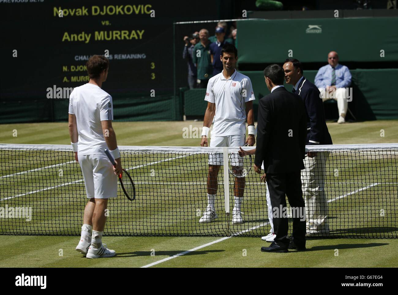 Serbias Novak Djokovic and Great Britains Andy Murray watch as the coin toss is performed before their Mens Singles Final during day thirteen of the Wimbledon Championships at The All England Lawn