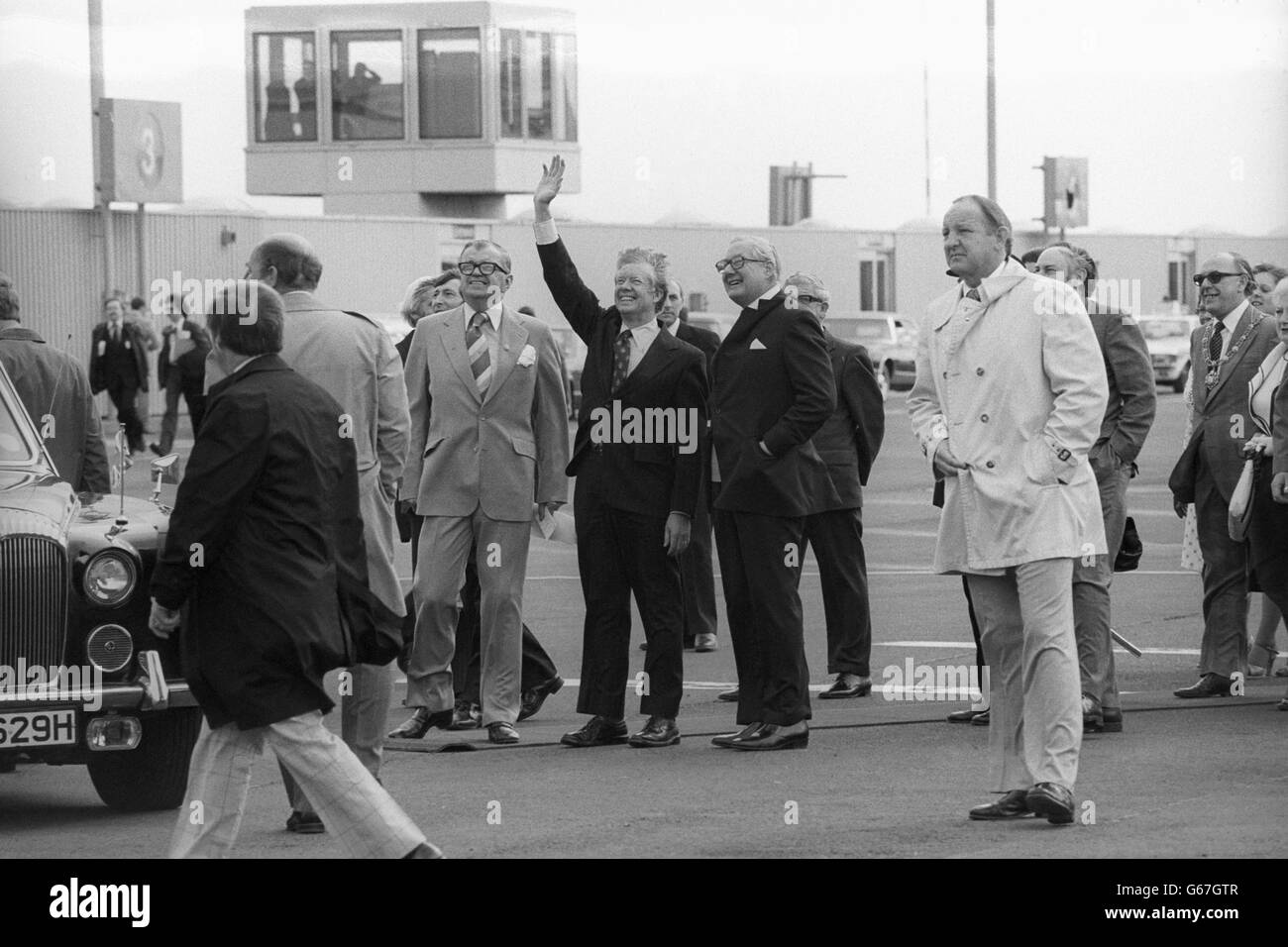 American President Jimmy Carter, in Britain on his first foreign trip since becoming President of the United States, waves to crowds at Newcastle Airport. He is to meet PM James Callaghan (centre, right) before a tour of the North-East. 06/05/1977 Stock Photo