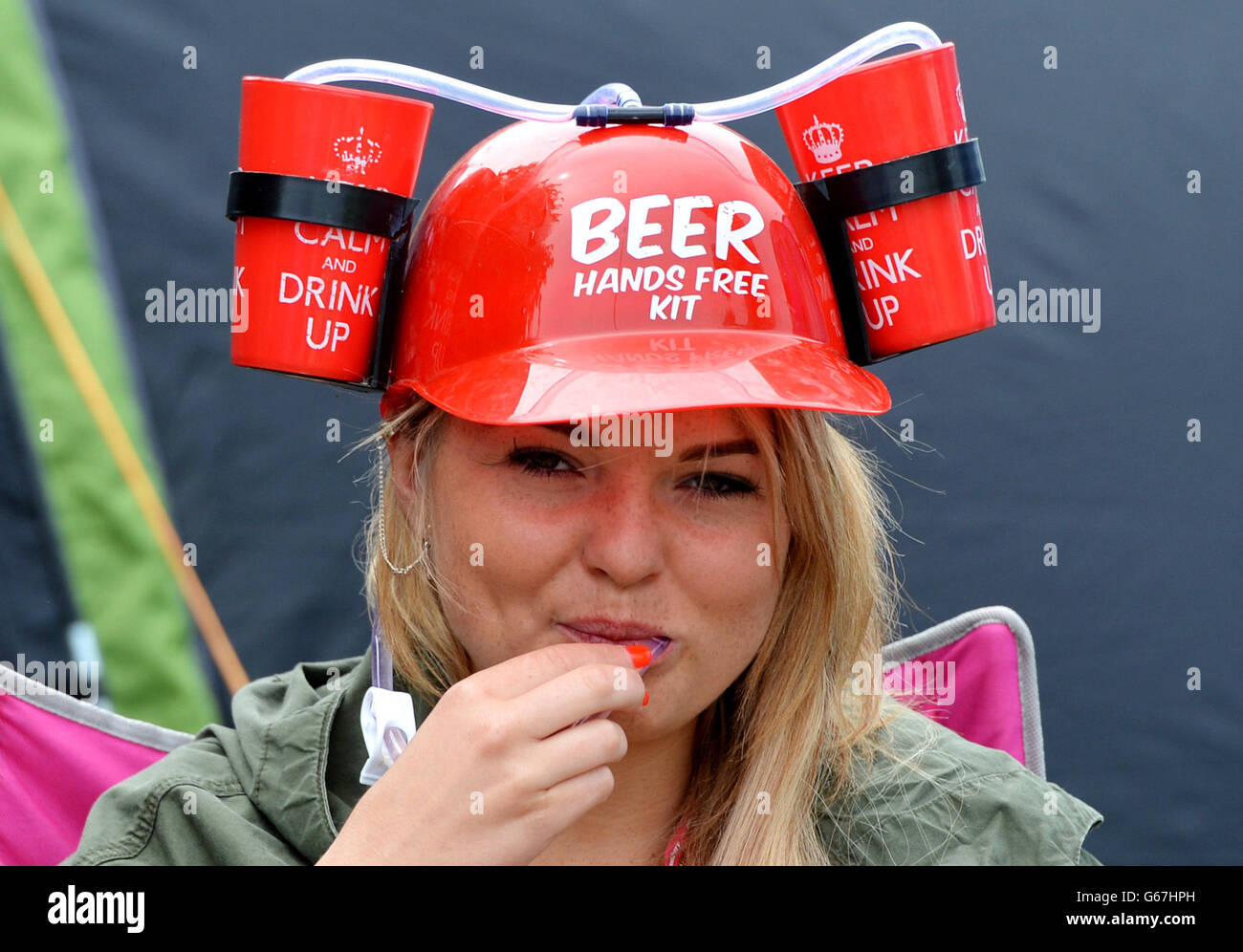 Woman drinks beer hat day glastonbury festival pilton farm hires stock
