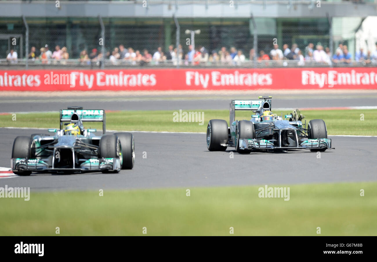 Mercedes' Lewis Hamilton (right with a burst tyre and Mercedes' Nico ...
