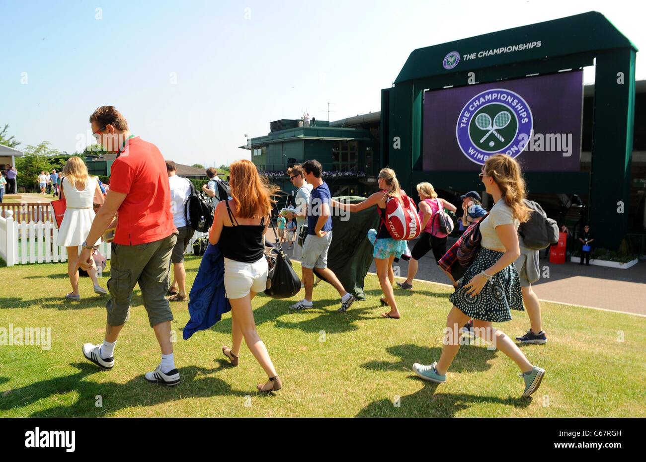 Fans run to take their places on Murray Mount during day thirteen of the Wimbledon Championships at The All England Lawn Tennis and Croquet Club, Wimbledon. Stock Photo