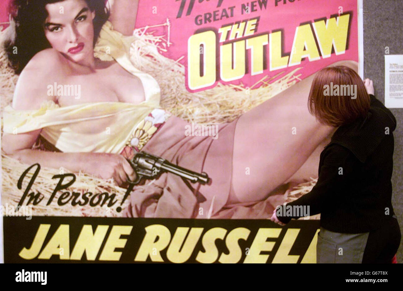 Huriec Gaidhg hangs the film poster for the 1943 Howard Hughes film 'The Outlaw' starring Jane Russell at Christies in London, as part of the Vintage Film Posters sale which starts tomorrow. It is estimated to be worth between 10,000 and 15,000. Stock Photo