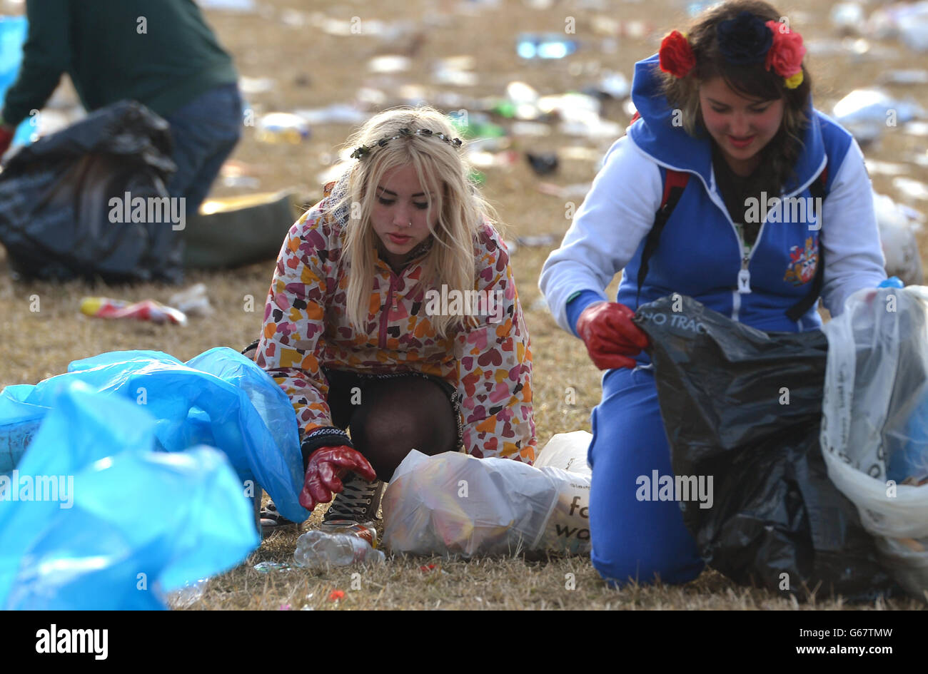 Cleaners pickup litter beside the Pyramid stage following the final day of the Glastonbury