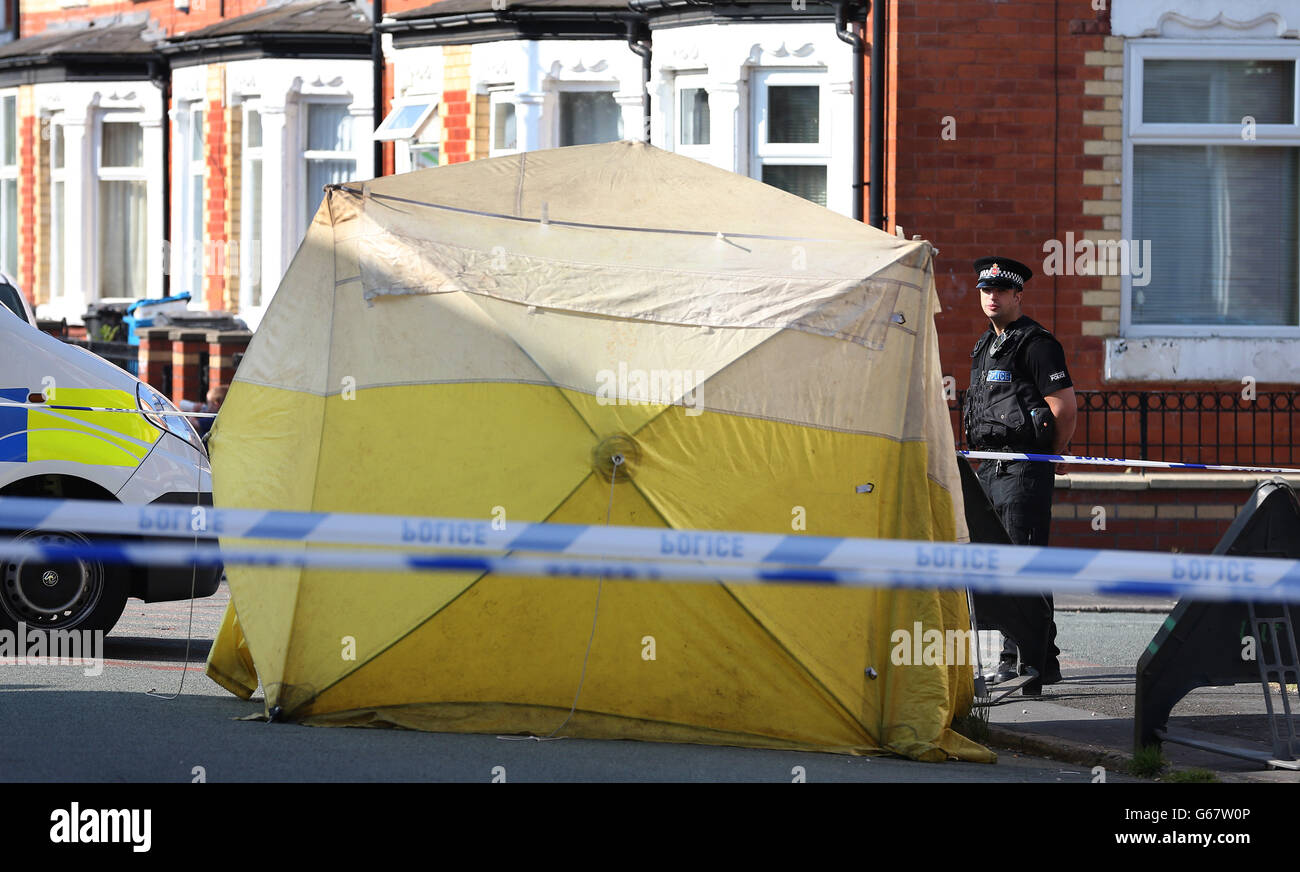 Police stand close to a forensic tent on Beard Road in Gorton, Manchester, following the death