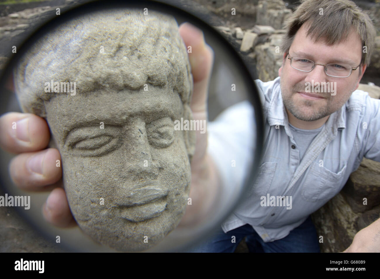 Lecturer in Archaeology at Durham University Dr David Petts at Binchester Roman Fort, near Bishop Auckland in County Durham holding an 1,800-year-old carved stone head of a possible Geordie Roman god. Stock Photo