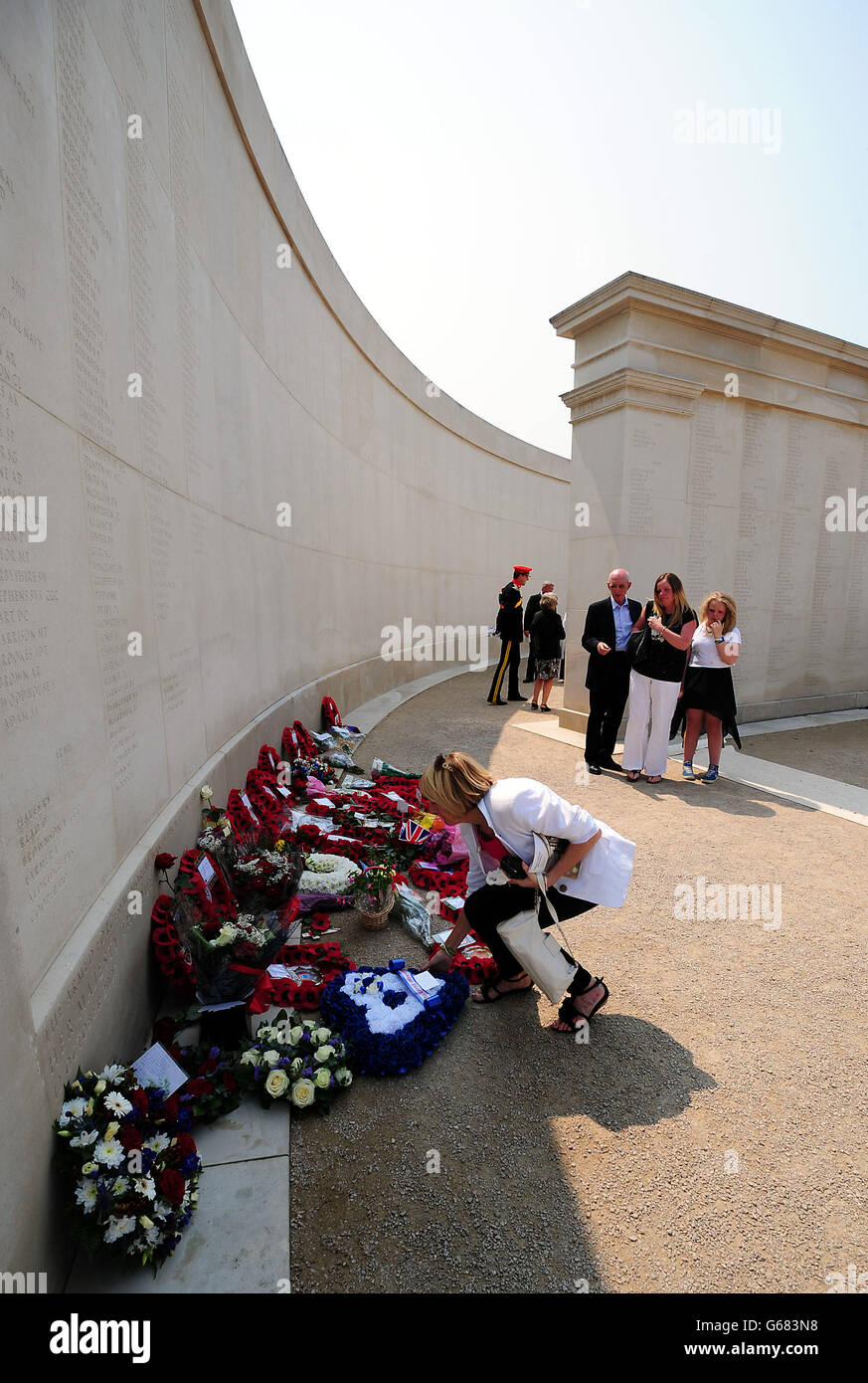 Families lay wreaths at the base of the Memorial after attending the ...